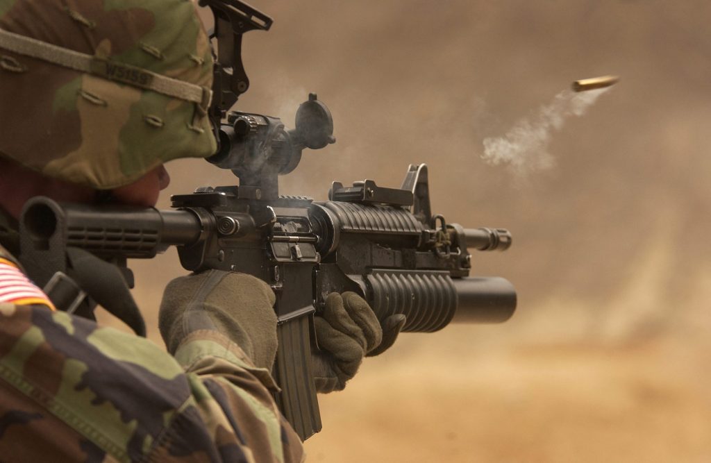Modern rifle being fired as a spent cartridge case ejects